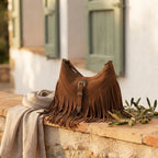 Brown fringe sling bag styled in a warm Mediterranean setting
