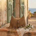 Khaki fringe sling bag styled in a warm Mediterranean setting