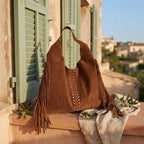 Brown fringe studded bag styled in a warm Mediterranean setting