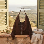 Coffee fringe studded bag styled in a warm Mediterranean setting
