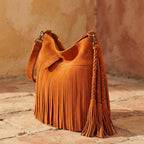 Orange fringe tassel shoulder bag, three-quarter angle showing side depth
