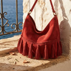 Red fringe tassel shoulder bag styled in a warm Mediterranean setting