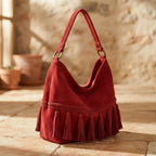 Red fringe tassel shoulder bag, three-quarter angle showing side depth