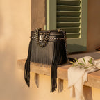 Black fringe tassel small bag styled in a warm Mediterranean setting