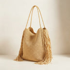 Natural fringed straw tote bag, three-quarter angle showing side depth