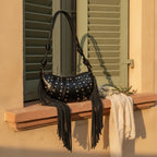 Black genuine leather fringe bag styled in a warm Mediterranean setting
