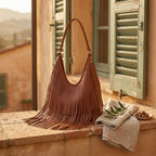 Brown genuine leather fringe hobo bag styled in a warm Mediterranean setting