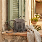 Grey gray crossbody bag fringe styled in a warm Mediterranean setting