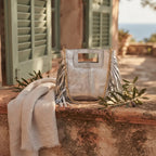 Silver gray fringe satchel bag styled in a warm Mediterranean setting