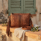 Coffee handcrafted leather fringe crossbody bag styled in a warm Mediterranean setting