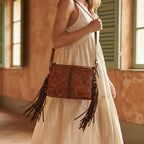 Woman wearing Coffee handcrafted leather fringe crossbody bag with swaying fringe