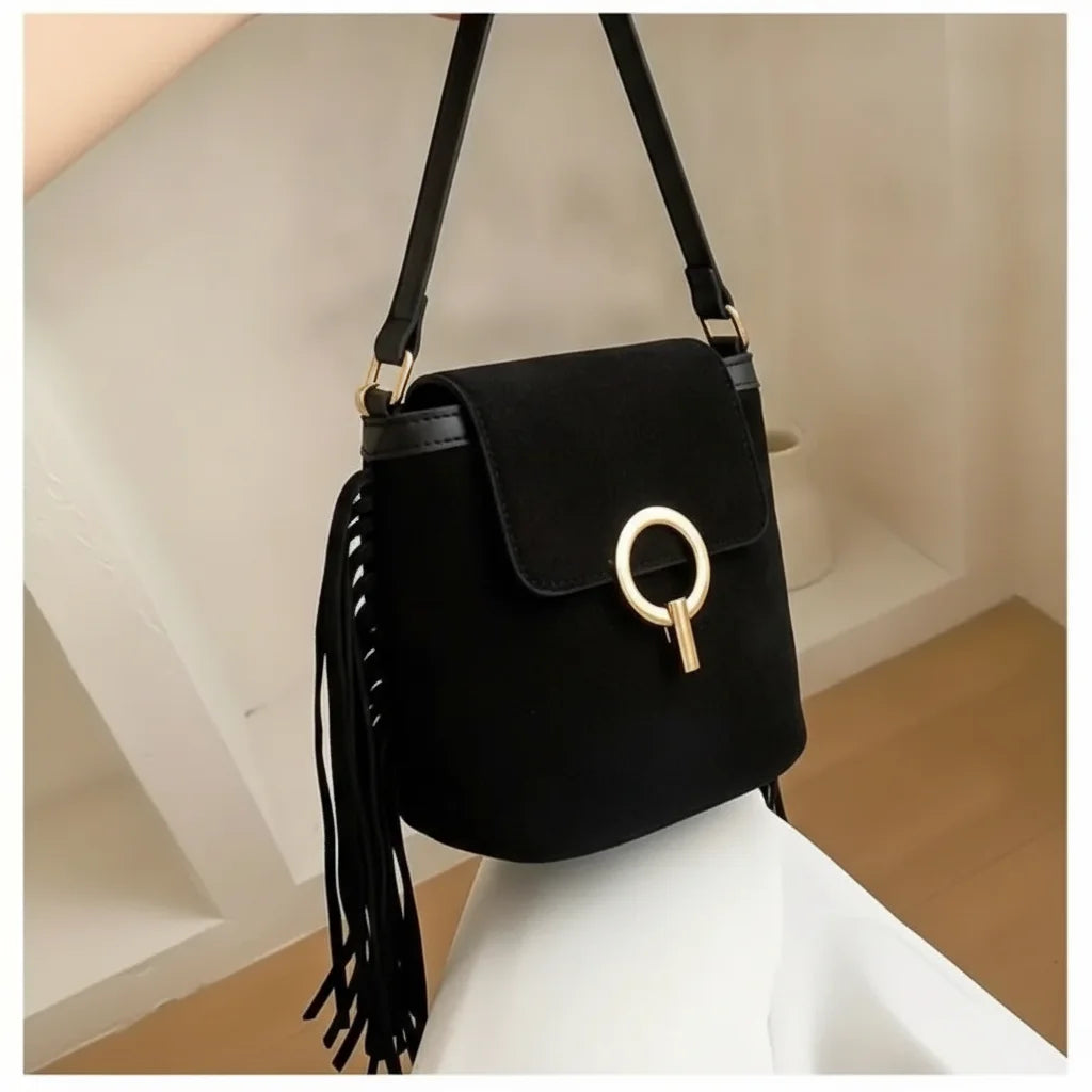 Black hippie fringe crossbody bag, three-quarter angle showing side depth