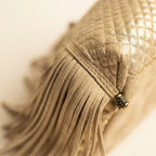 Close-up of fringe stitching and texture on Gold large fringe clutch bag