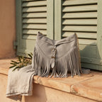 Grey large fringe crossbody bag styled in a warm Mediterranean setting