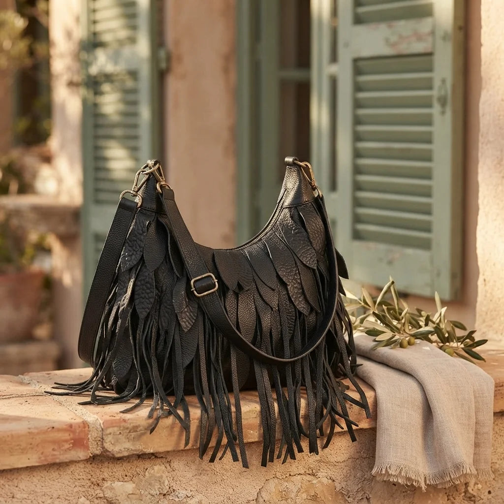 Black large fringe faux leather hobo bag styled in a warm Mediterranean setting