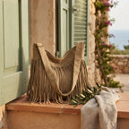 Khaki large fringe hobo bag styled in a warm Mediterranean setting