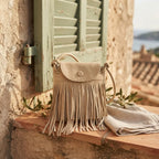 Beige large fringe shoulder bags styled in a warm Mediterranean setting