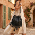 Woman wearing Black leather bucket bag with fringes with swaying fringe
