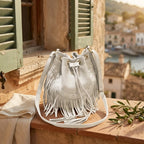 White leather bucket bag with fringes styled in a warm Mediterranean setting