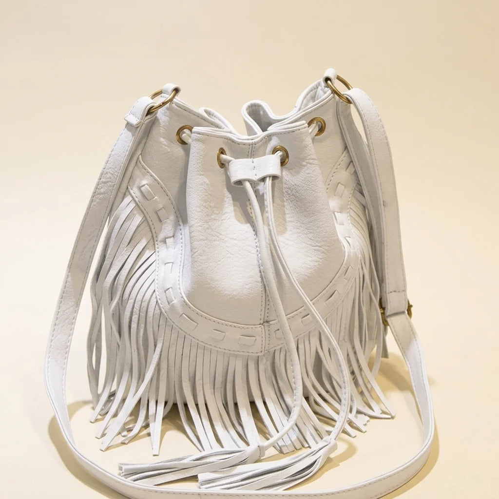 White leather bucket bag with fringes, three-quarter angle showing side depth