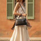 Woman wearing Black leather clutch bags with side fringe with swaying fringe