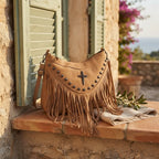 Khaki leather fringe messenger bag styled in a warm Mediterranean setting