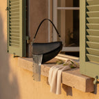Black leather saddle bag fringe styled in a warm Mediterranean setting