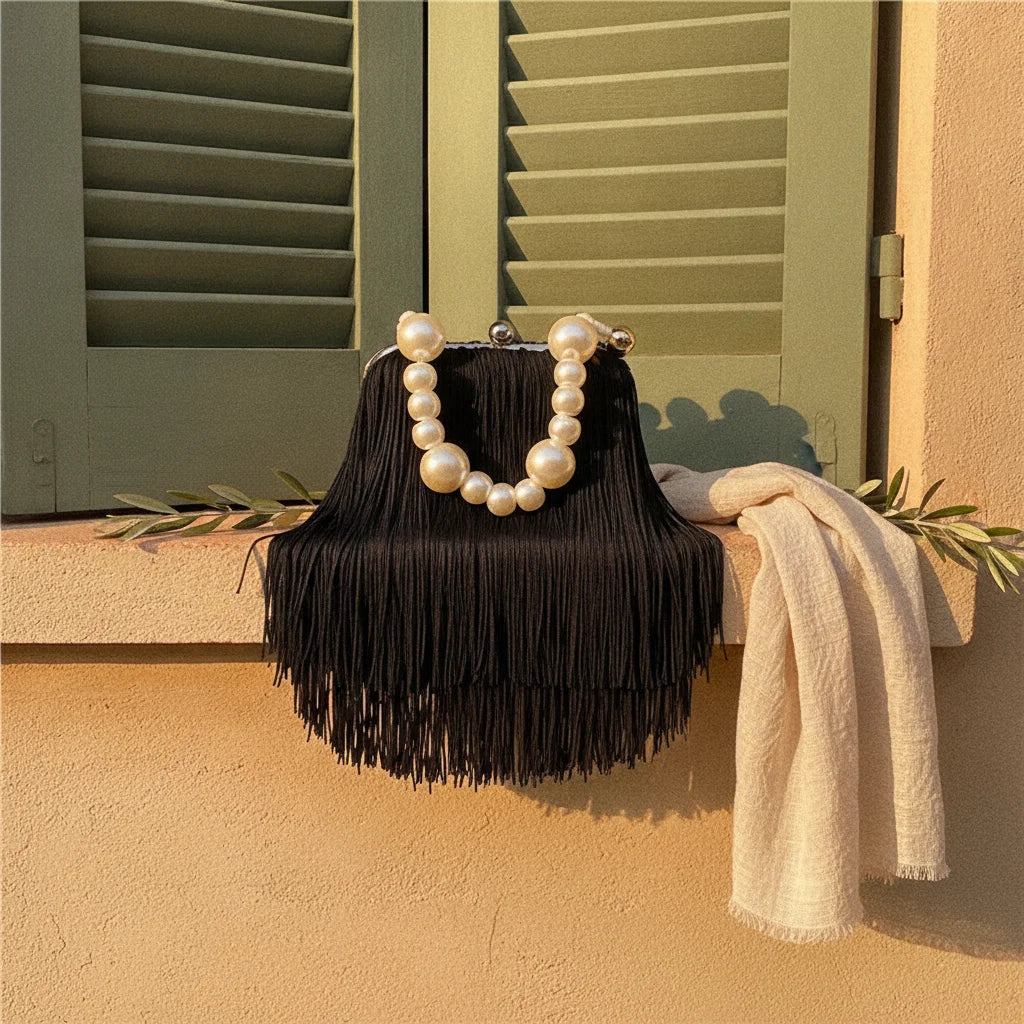 Black long fringe clutch bag styled in a warm Mediterranean setting