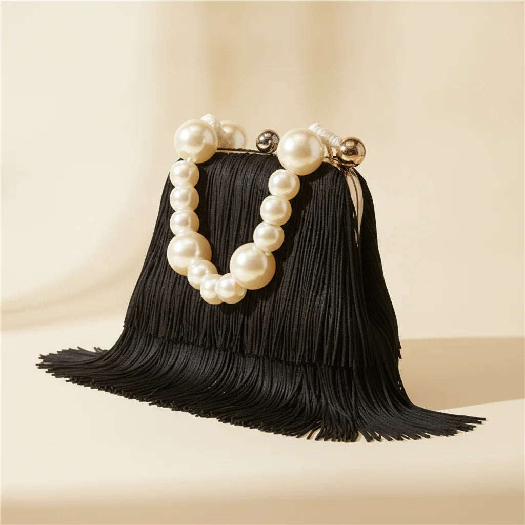 Black long fringe clutch bag, three-quarter angle showing side depth