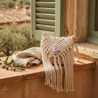 Beige macrame fringe bag styled in a warm Mediterranean setting