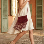 Woman wearing Burgundy mini fringe crossbody bag with swaying fringe