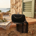 black fringe evening bag styled in a warm Mediterranean setting
