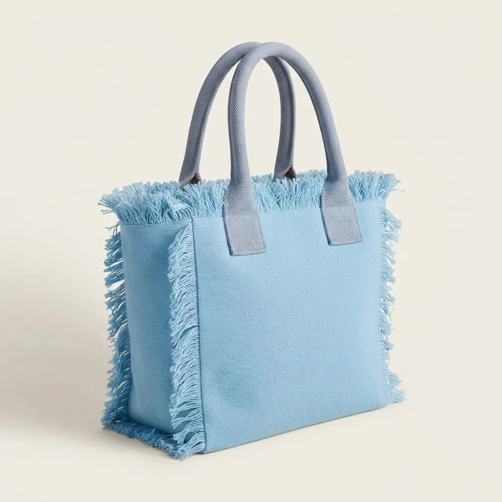 Light Blue oversized beach bag fringe, three-quarter angle showing side depth
