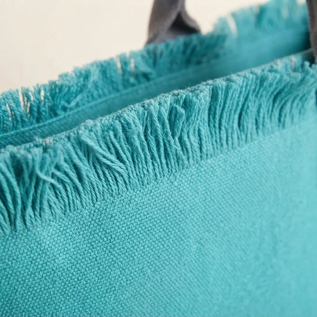Close-up of fringe stitching and texture on Turquoise beach bag