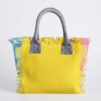 Yellow oversized beach bag fringe, three-quarter angle showing side depth