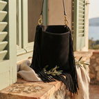 Black oversized fringe bag styled in a warm Mediterranean setting