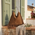 Brown oversized fringe bag styled in a warm Mediterranean setting