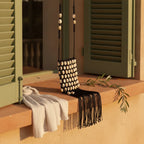 Black pearl fringe clutch bag styled in a warm Mediterranean setting