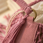 Close-up of fringe stitching and texture on Pink pink bucket bag with fringe