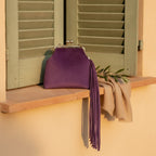 Purple purple fringe clutch bag styled in a warm Mediterranean setting