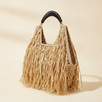 Natural raffia fringe crescent bag, three-quarter angle showing side depth