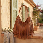 Brown slouchy fringe bag styled in a warm Mediterranean setting