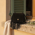 Black small fringe bag styled in a warm Mediterranean setting