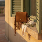 Brown small fringe bag styled in a warm Mediterranean setting