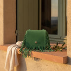 Green small fringe bag styled in a warm Mediterranean setting