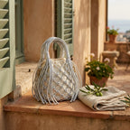 Silver small fringe bucket bag styled in a warm Mediterranean setting