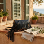 Black small fringe leather crossbody bag styled in a warm Mediterranean setting