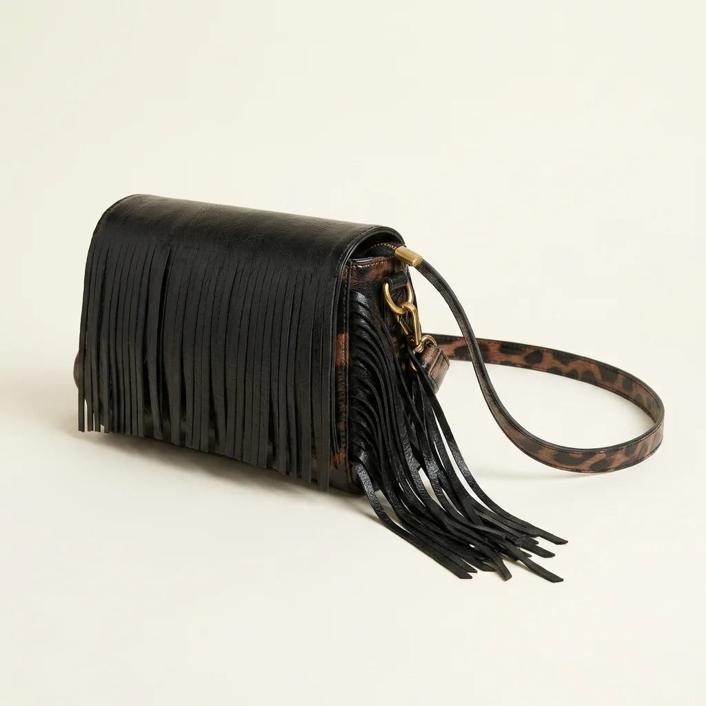 Black small fringe leather crossbody bag, three-quarter angle showing side depth