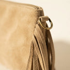 Close-up of fringe stitching and texture on Beige small suede fringe bag