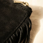 Close-up of fringe stitching and texture on Black small suede fringe bag